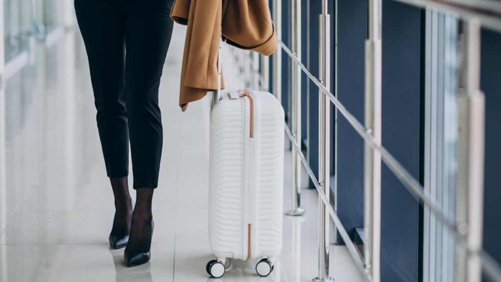 Services de conciergerie privée par Tyché Company. Photo valise à l'aéroport femme d'affaires.